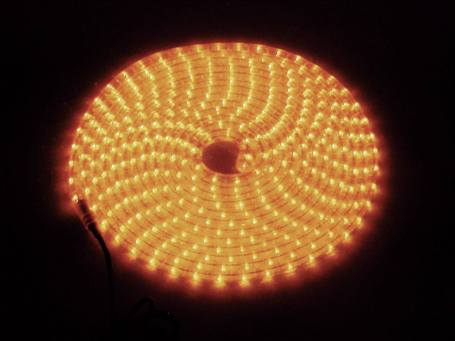 Ein kreisförmig angeordneter LED-Lichtstreifen leuchtet in hellem Orange, mit einem Kabel an der Seite.
