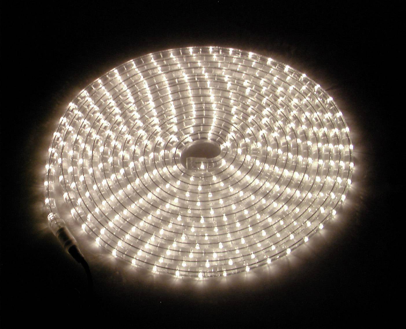 Ein aufgerolltes LED-Lichtband, das warmes Licht ausstrahlt, liegt auf einem dunklen Hintergrund.