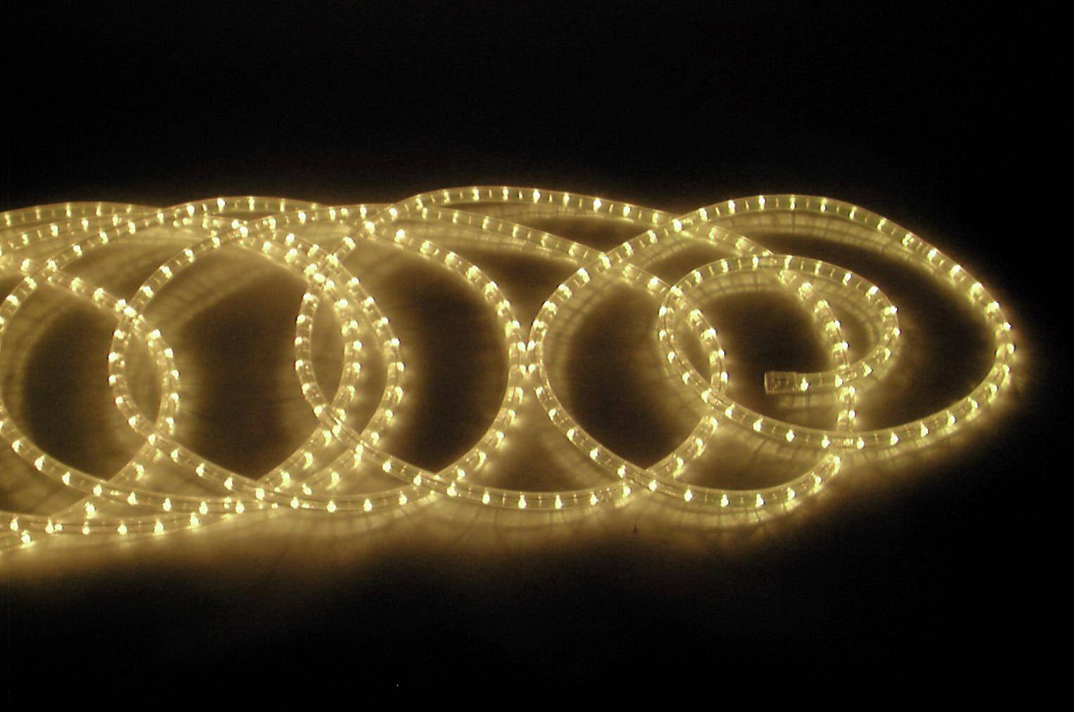 Leuchtende LED-Lichtschläuche in einer spiralförmigen Anordnung auf schwarzem Hintergrund. Sie strahlen warmes, goldenes Licht aus.
