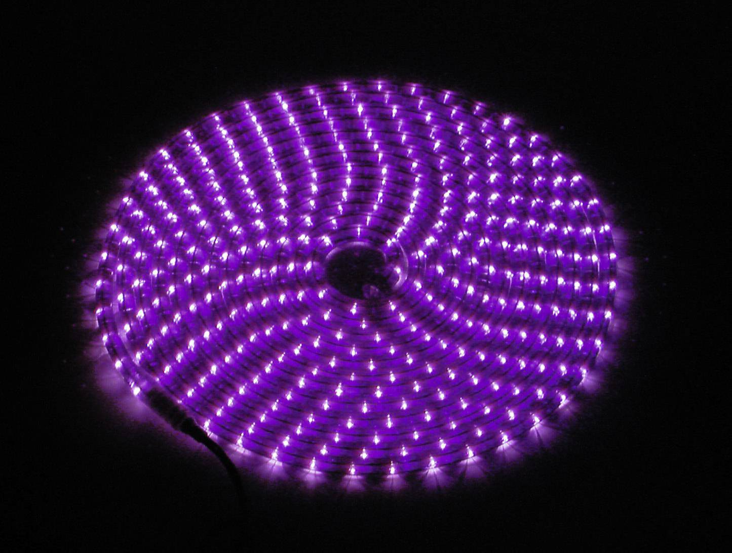 Lila LED-Leuchtring aus mehreren Reihen, die ein spiralförmiges Muster bilden, auf dunklem Hintergrund.
