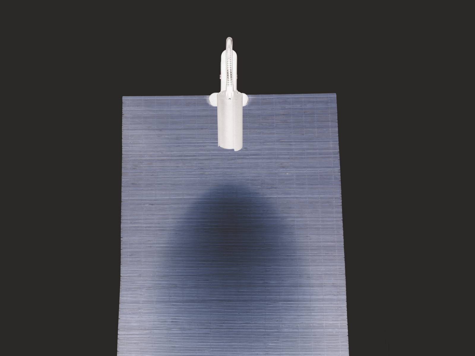 Ein weißes U-Boot-Modell schwimmt auf einem wellenförmigen dunklen Wasserstruktur-Hintergrund, das Licht schafft einen Schatteneffekt.