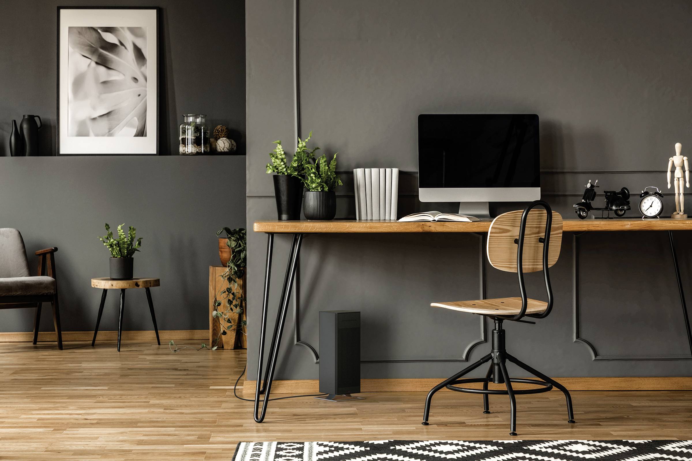 Moderner Arbeitsbereich mit Holzschreibtisch, Stuhl, Computer, Pflanzen und dekorativen Elementen in einem stilvollen Raum.
