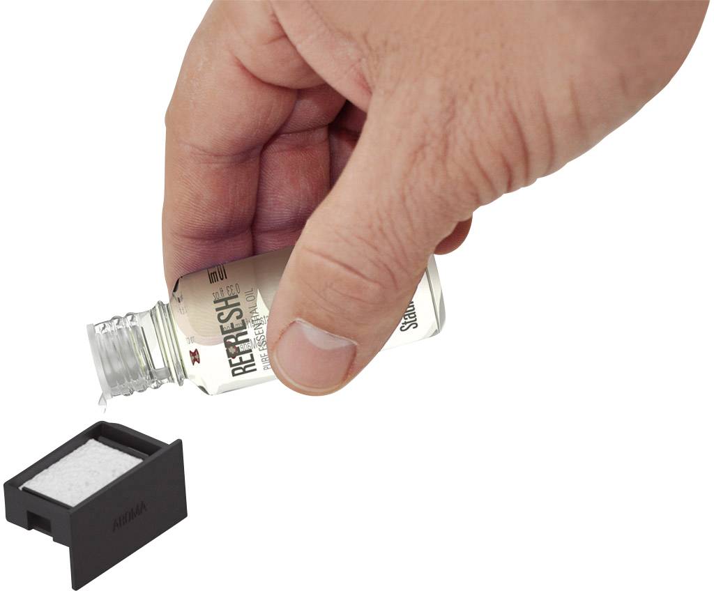 Eine Hand gießt Flüssigkeit aus einer kleinen Flasche in einen schwarzen Behälter ein.