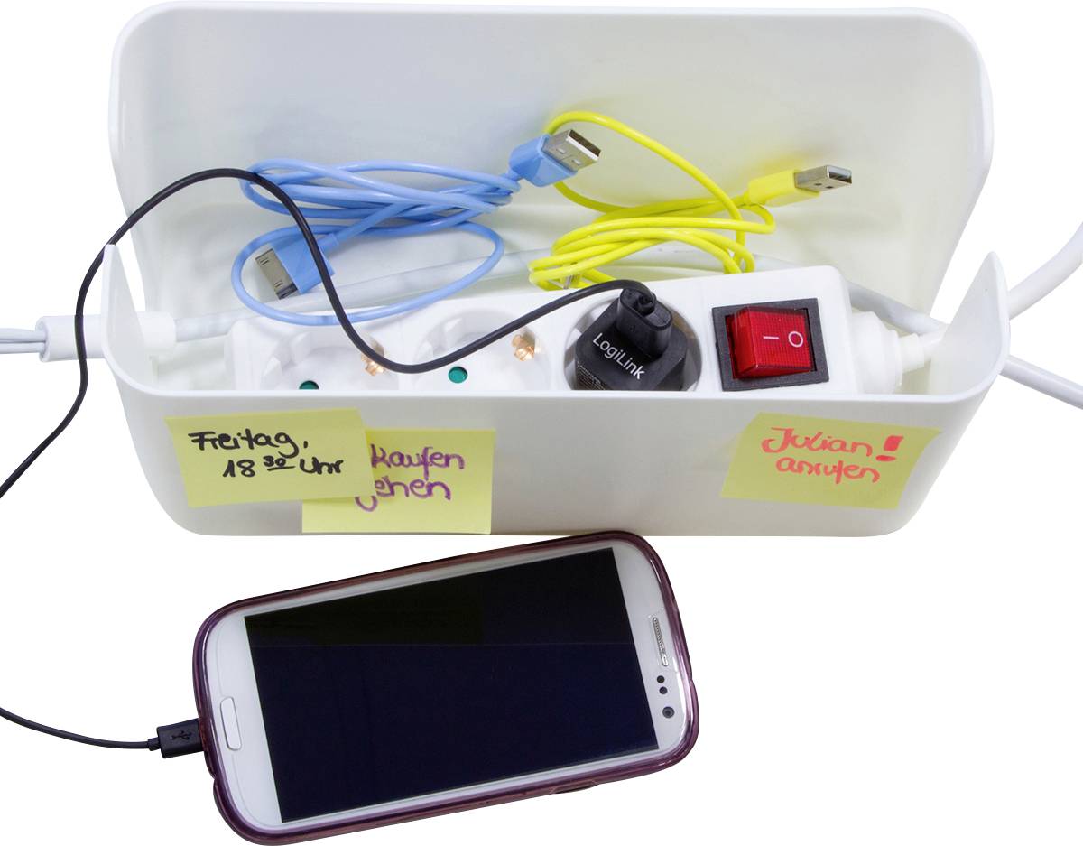 Ein Smartphone lädt über ein Verlängerungskabel, das in einer Box mit gelbem und blauem Kabel sowie Schalter verstaut ist.