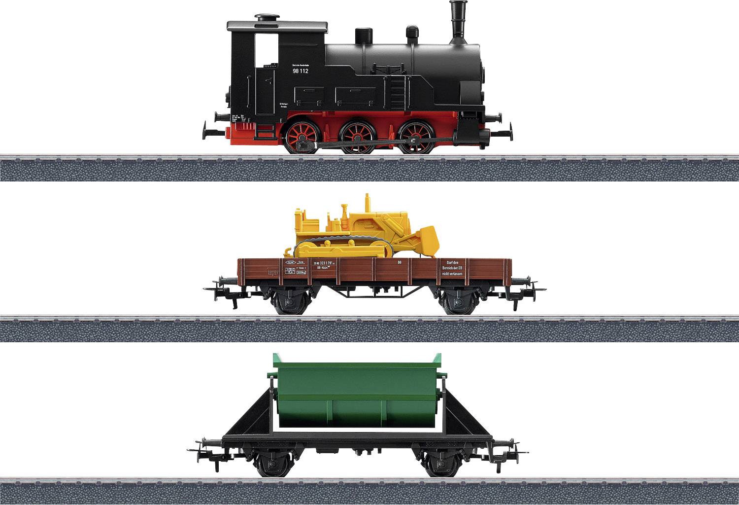 Eine Modelleisenbahn mit schwarzer Dampflok, flachem Güterwagen mit gelbem Traktor und grünem Kippwagen, seitlich auf Schienen.