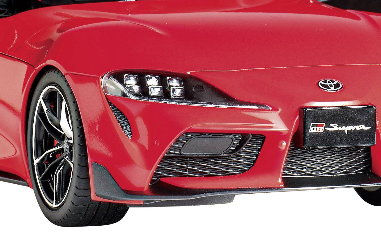 Nahaufnahme eines roten Sportwagens mit markantem Frontdesign und Logo auf dem Kühlergrill.