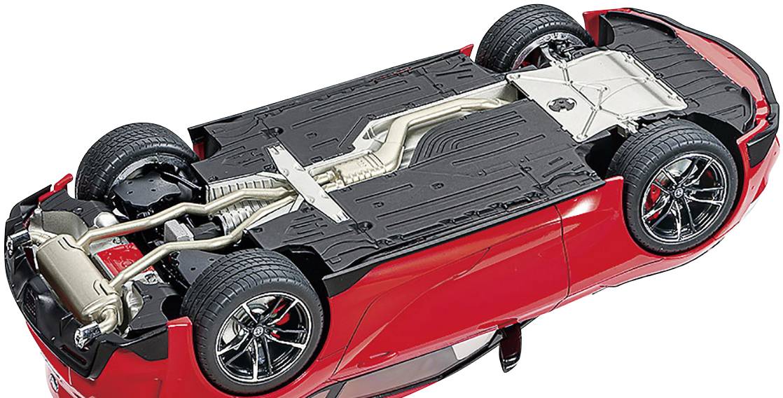 Roter Sportwagen von unten, zeigt Fahrwerk, Auspuffsystem und Reifen. Fokussiert auf Fahrzeugtechnik und Design des Unterbodens.
