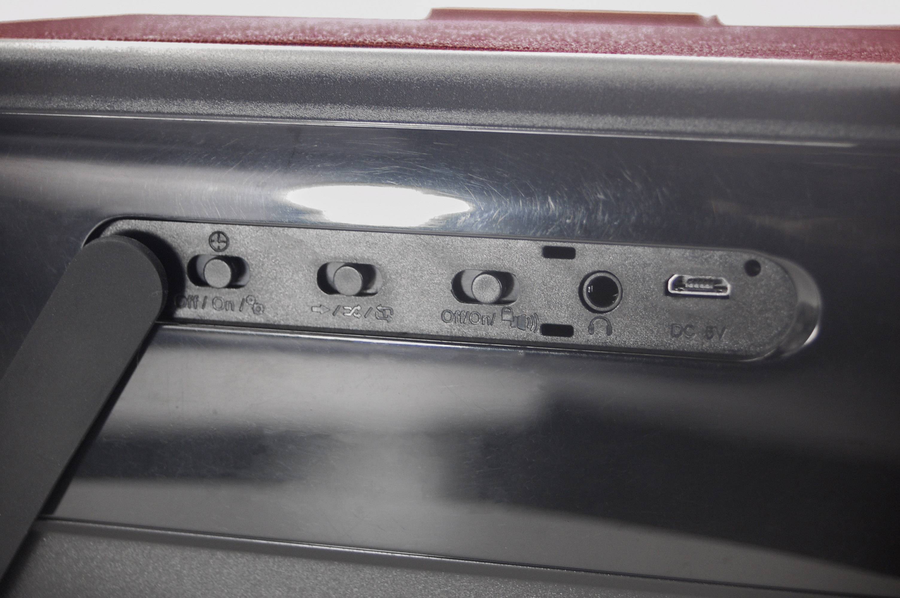 'Rückseite eines Geräts mit Anschlüssen: USB-Anschluss, Kopfhörerbuchse und vier Tasten für verschiedene Funktionen.'