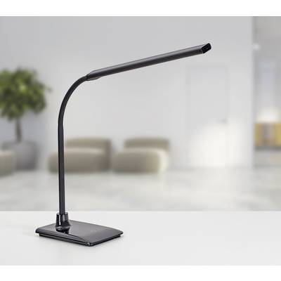 Schwarze LED-Schreibtischlampe mit flexiblem Arm steht auf einem weißen Schreibtisch in einem modernen, minimalistisch eingerichteten Raum.