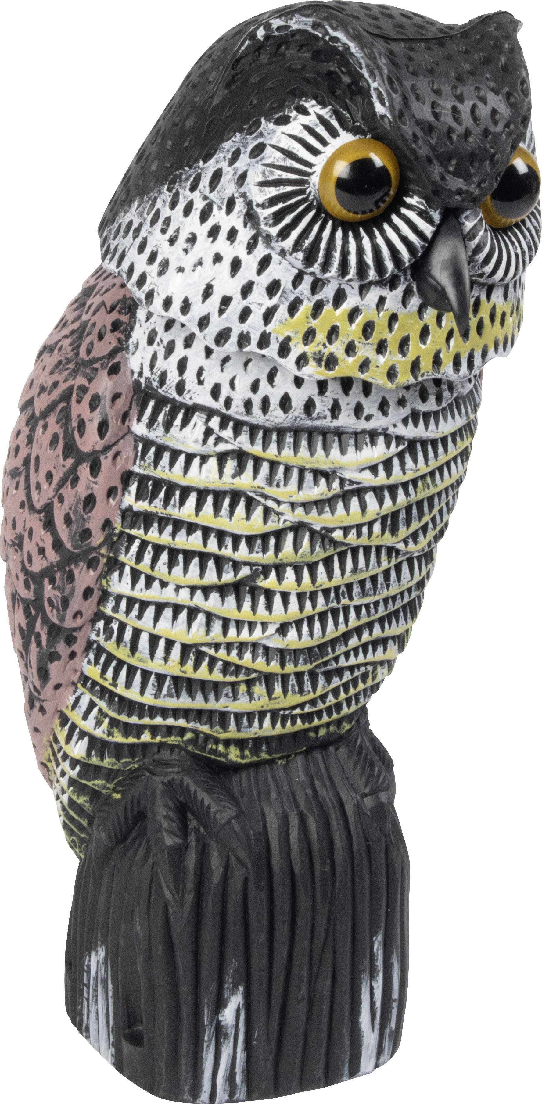 Eine detailliert geschnitzte Holzskulptur einer Eule, bemalt in Schwarz, Weiß, Gelb und Rosa, sitzt auf einem kleinen Sockel.