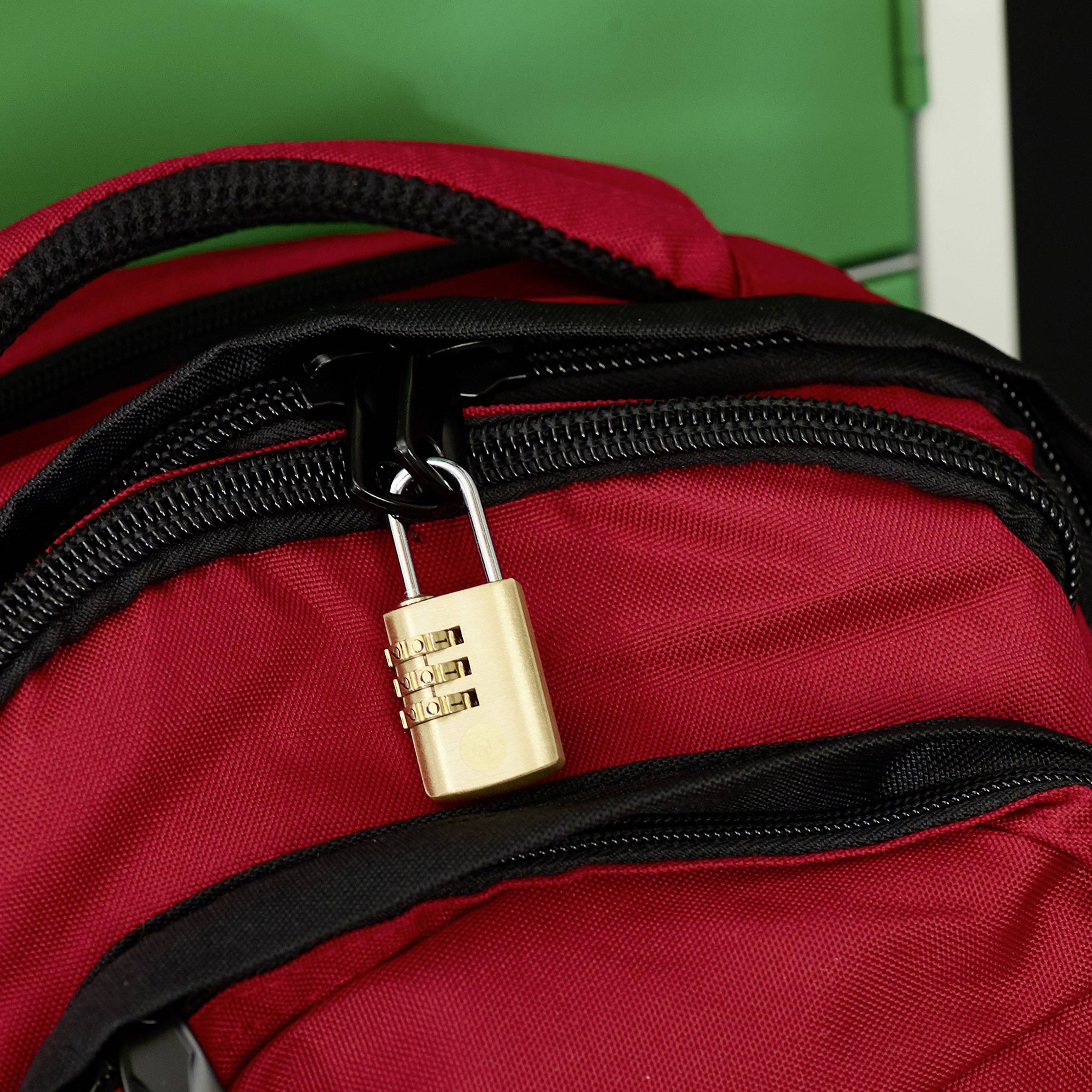 Ein roter Rucksack mit einem Zahlenschloss am Reißverschluss. Im Hintergrund ist ein grünes Objekt zu sehen.