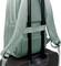 Ein grüner Rucksack ist auf einem schwarzen Rollkoffer befestigt, indem er mit einem Gurt über die Teleskopgriffe gesichert ist.