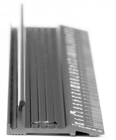Linealähnliches Messgerät aus Metall mit erhabenen Schienen und Zahlen. Es wird zur präzisen Längenmessung verwendet.