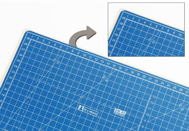 Blaue Schneidematte mit Zentimeter-Raster und Markierungen für DIN A5. Pfeil zeigt auf eine Ecke der Matte, die vergrößert dargestellt wird.