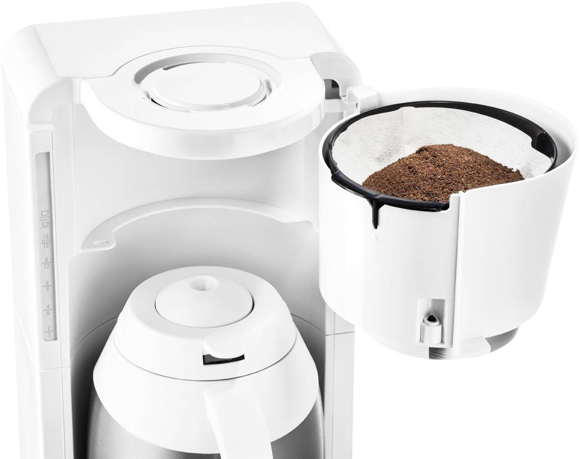 Eine Kaffeemaschine mit entnommenem Filterhalter, gefüllt mit gemahlenem Kaffee. Daneben steht eine silberne Kaffeekanne.