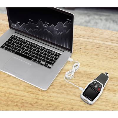 Ein Laptop mit einer grafischen Analyse auf dem Bildschirm ist per USB-Kabel mit einem Messgerät verbunden, das auf einem Holztisch liegt.