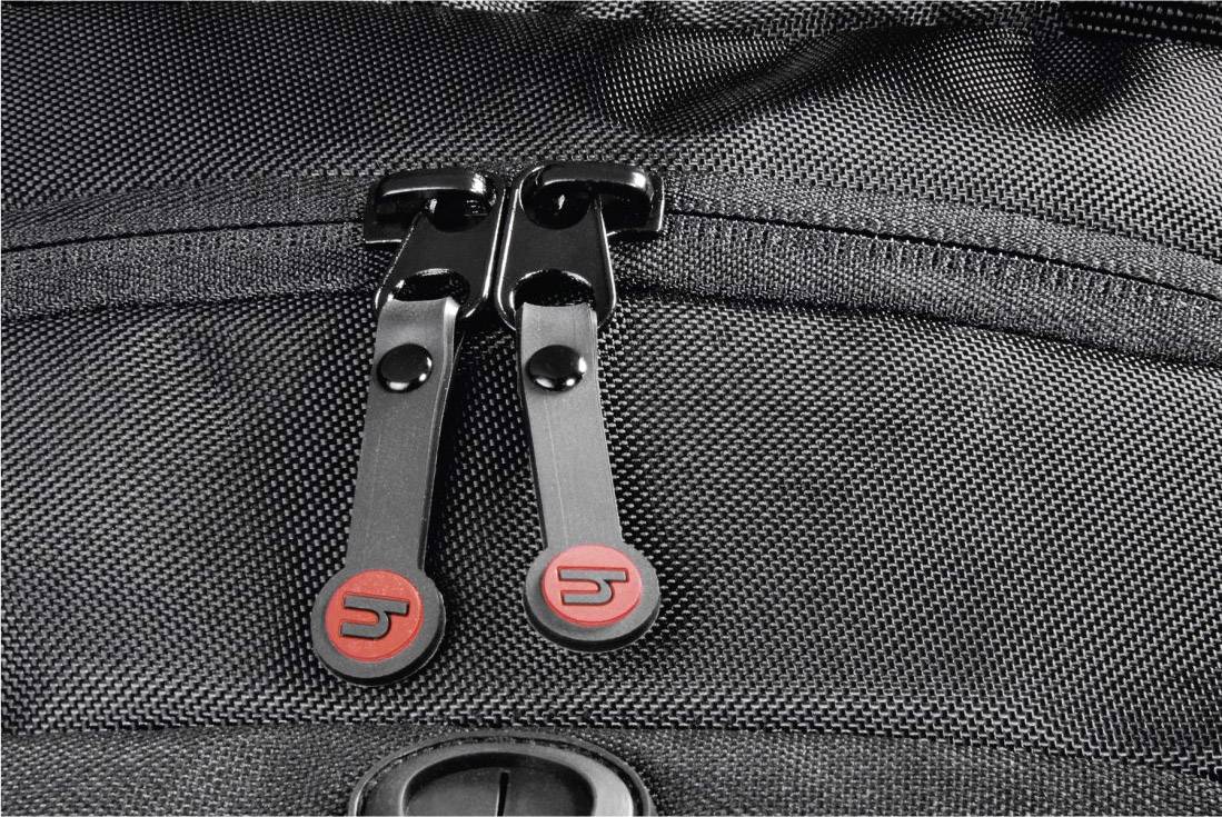 Nahaufnahme eines schwarzen Reißverschlusses an einer Tasche, mit zwei roten Markenlogos auf den Zippern.