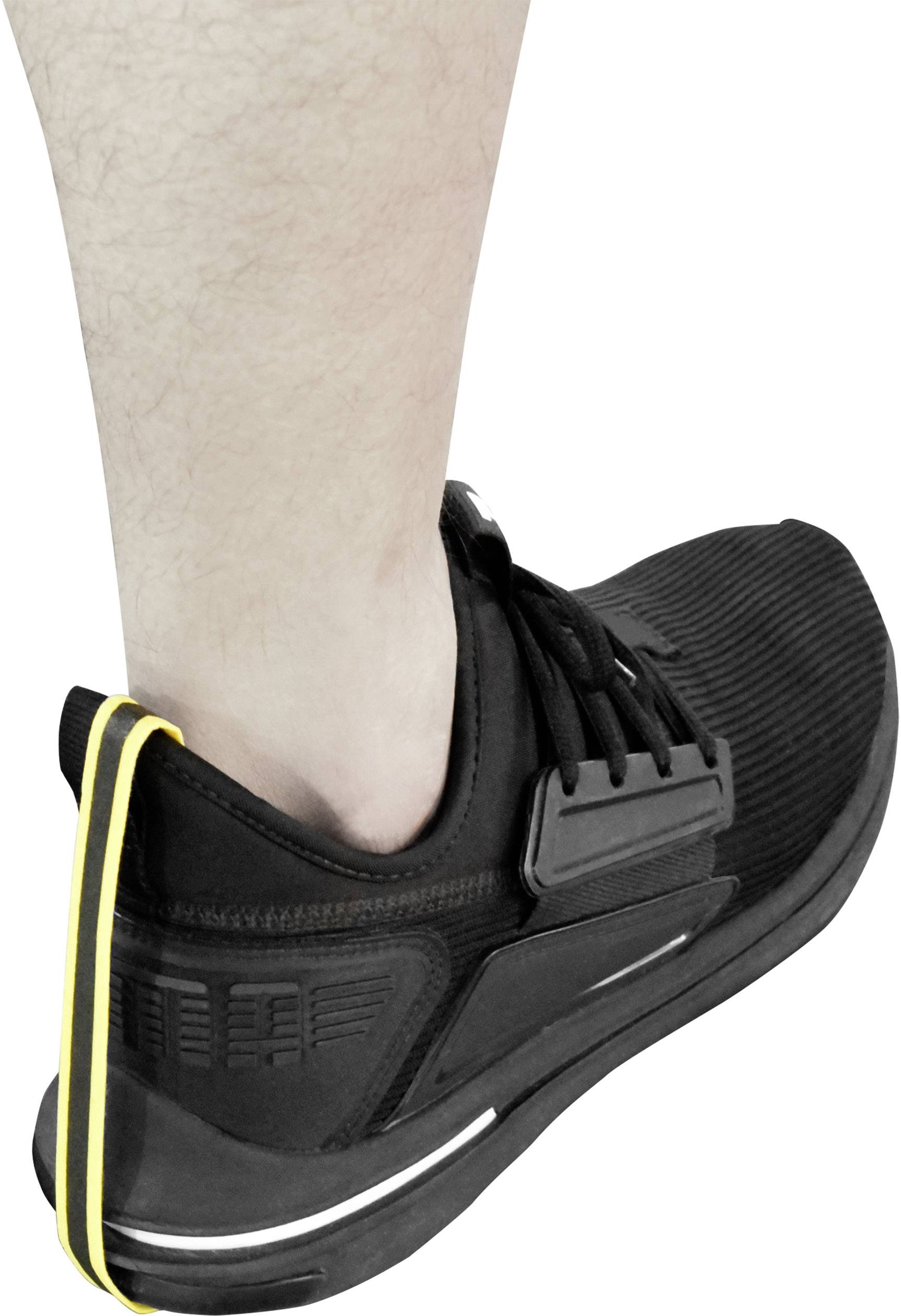 Ein Bein trägt einen schwarzen Sportschuh. Ein gelber Streifen verläuft entlang der Rückseite des Schuhs von der Sohle bis zum Schaft.