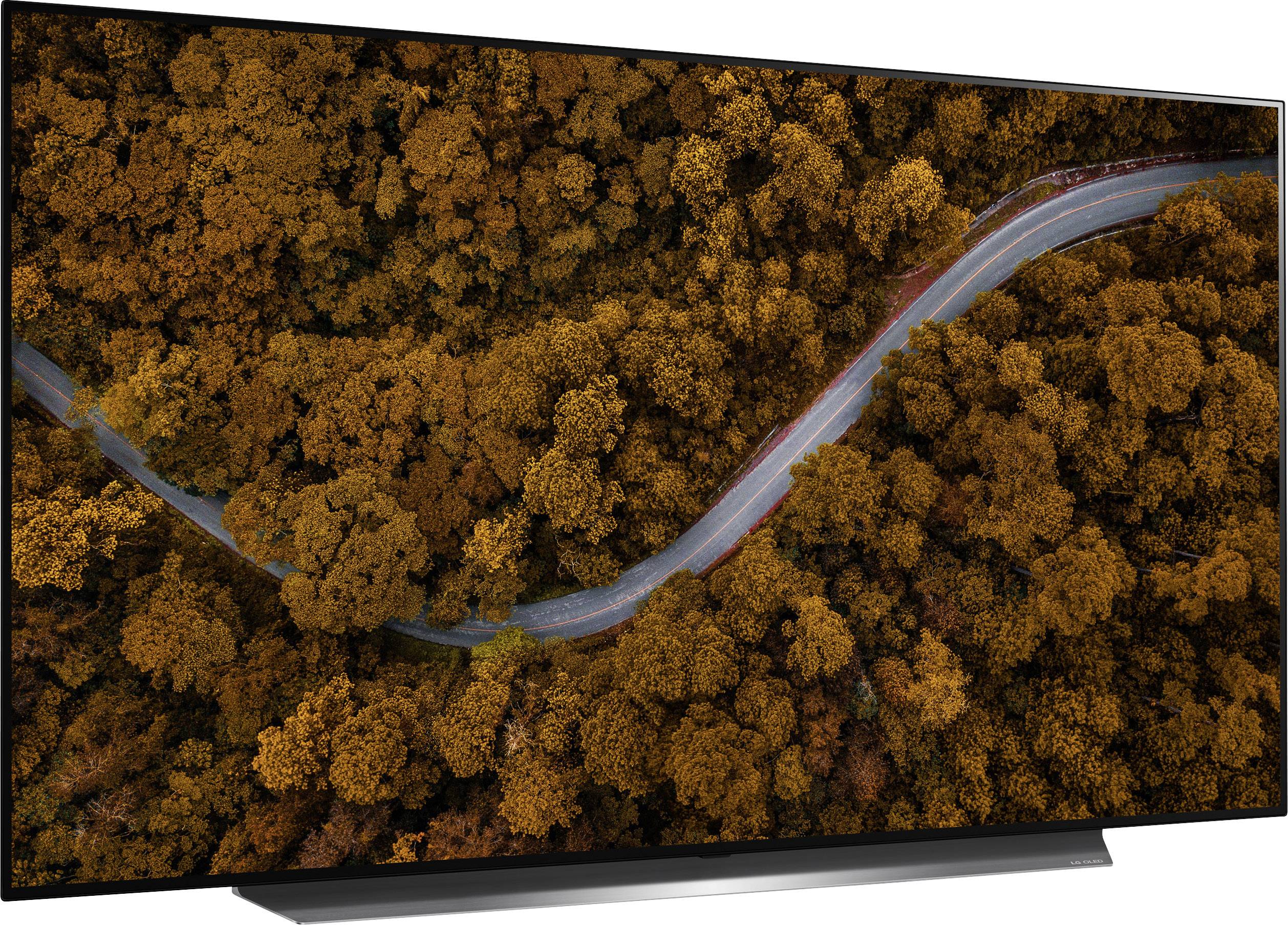 Eine Straße schlängelt sich durch einen Wald mit goldenen Herbstblättern, aus der Vogelperspektive fotografiert.