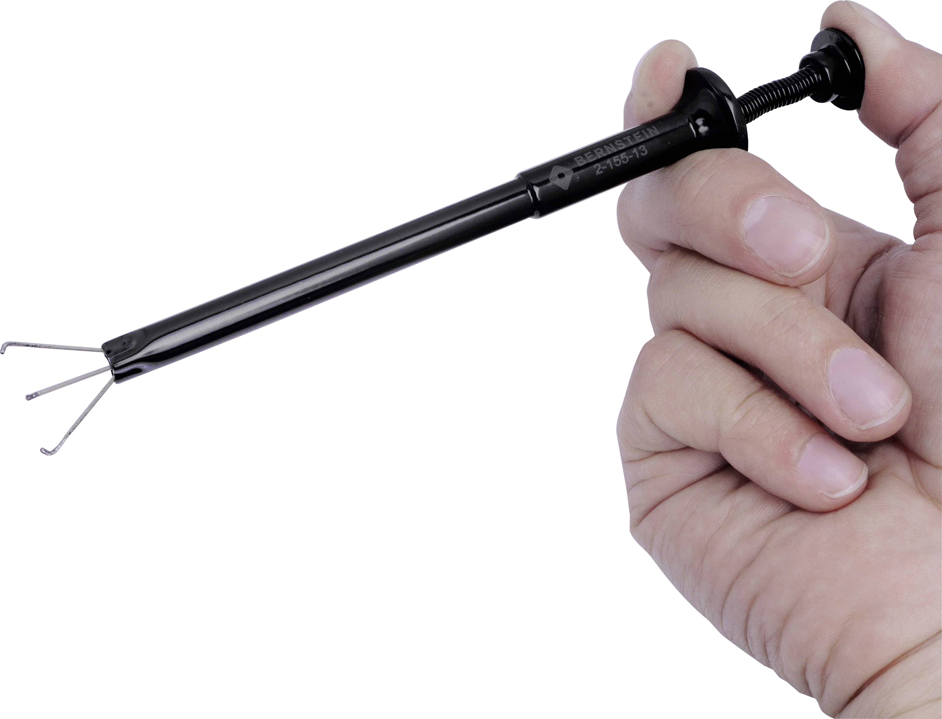 Eine Hand hält ein Werkzeug mit einem Greifmechanismus, bestehend aus drei dünnen Metallzangen, die herausragen.