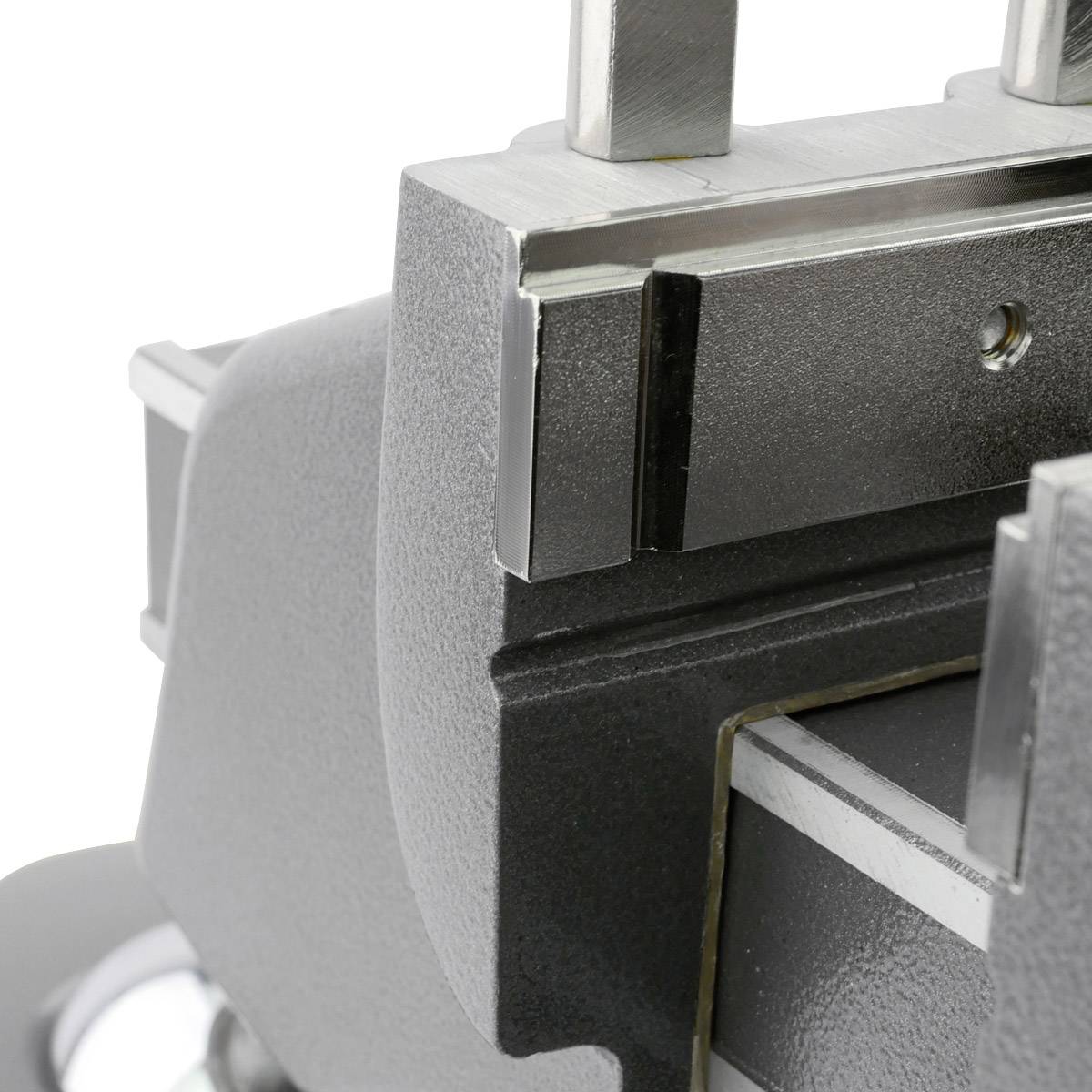 Nahaufnahme einer Metallbearbeitungsmaschine, die ein Metallstück festhält. Das Gerät scheint in einer Werkstatt verwendet zu werden.