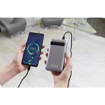 Eine Person hält ein Smartphone, das über ein Kabel mit einer tragbaren Powerbank verbunden ist. Das Smartphone zeigt einen Ladevorgang an.