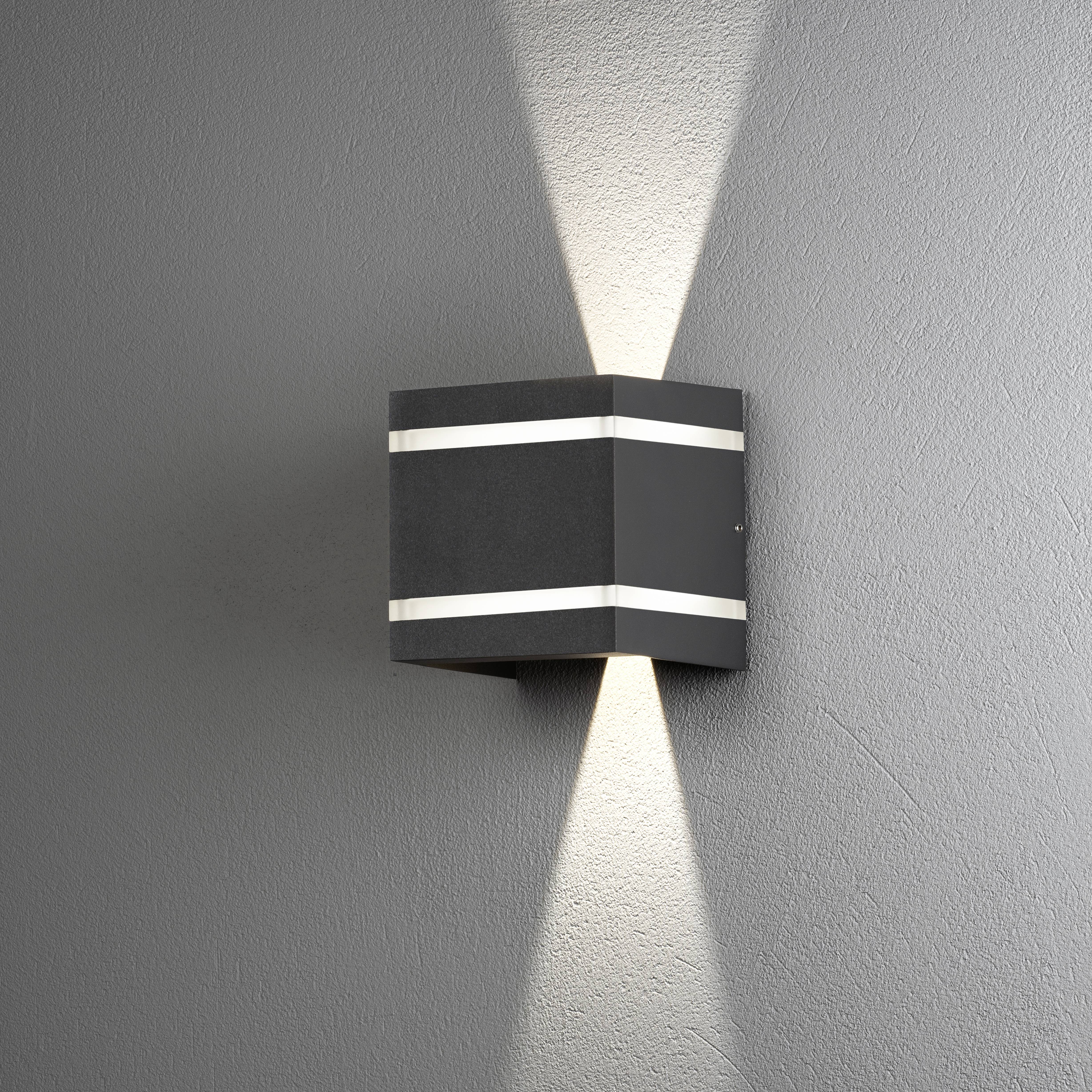 Wandleuchte aus schwarzem Metall mit zwei schmalen Lichtbändern. Beleuchtet die Wand nach oben und unten und erzeugt ein sanftes Lichtmuster.