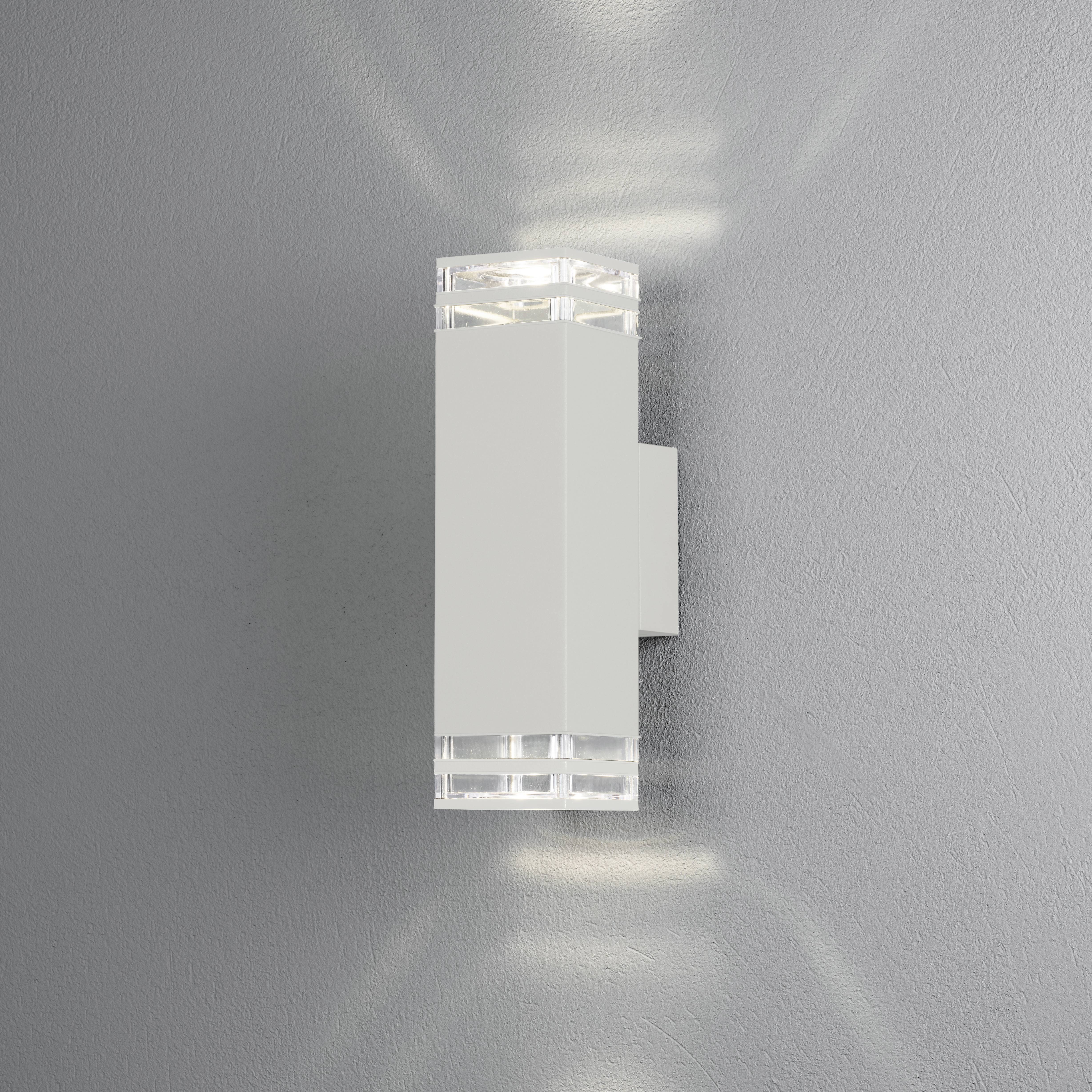 Wandleuchte mit rechteckigem, modernem Design leuchtet nach oben und unten. Schlichtes, stilvolles Erscheinungsbild auf grauer Wand.