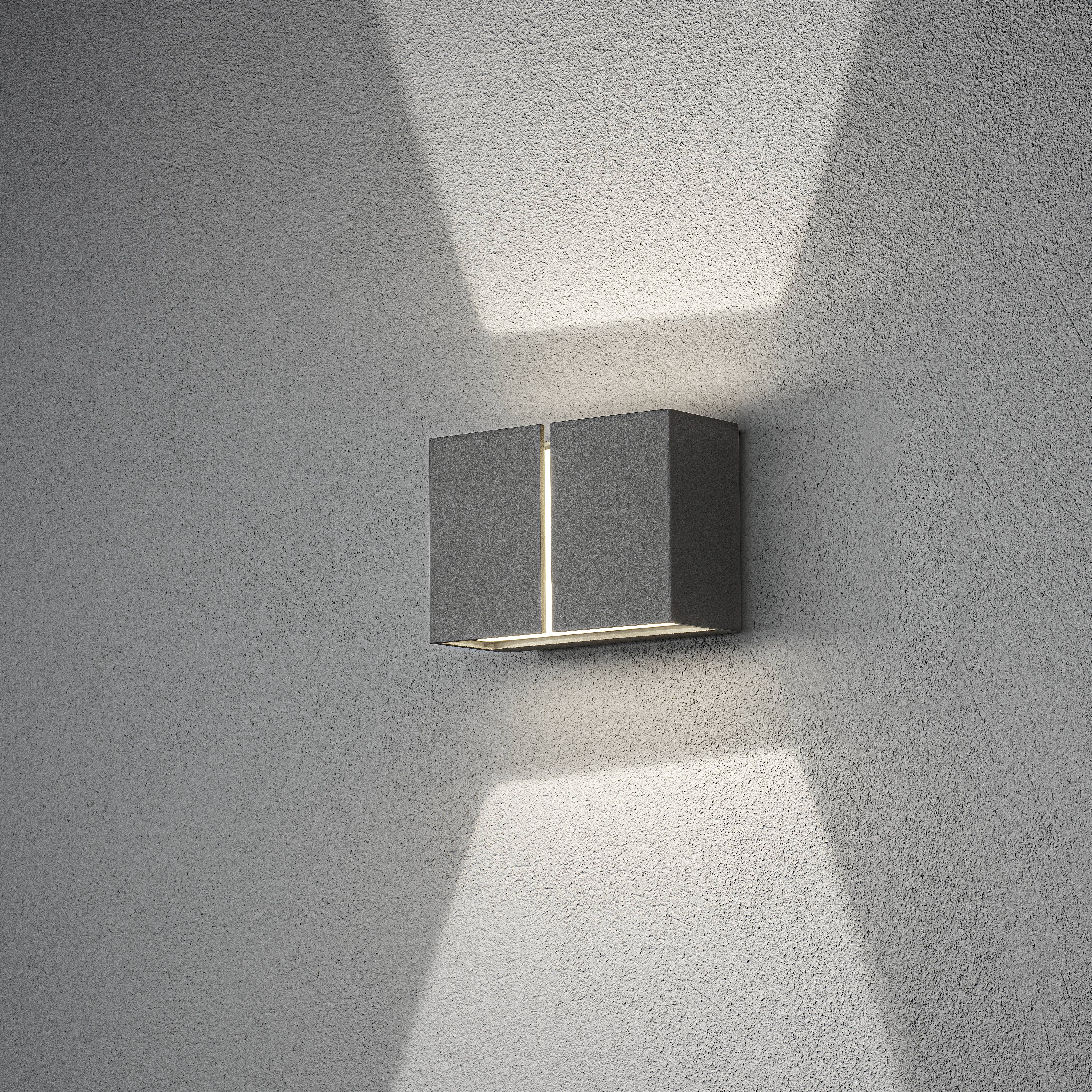 Wandleuchte aus Metall mit modernem Design strahlt Licht nach oben und unten an die Wand, erzeugt ein dezentes Lichtmuster.