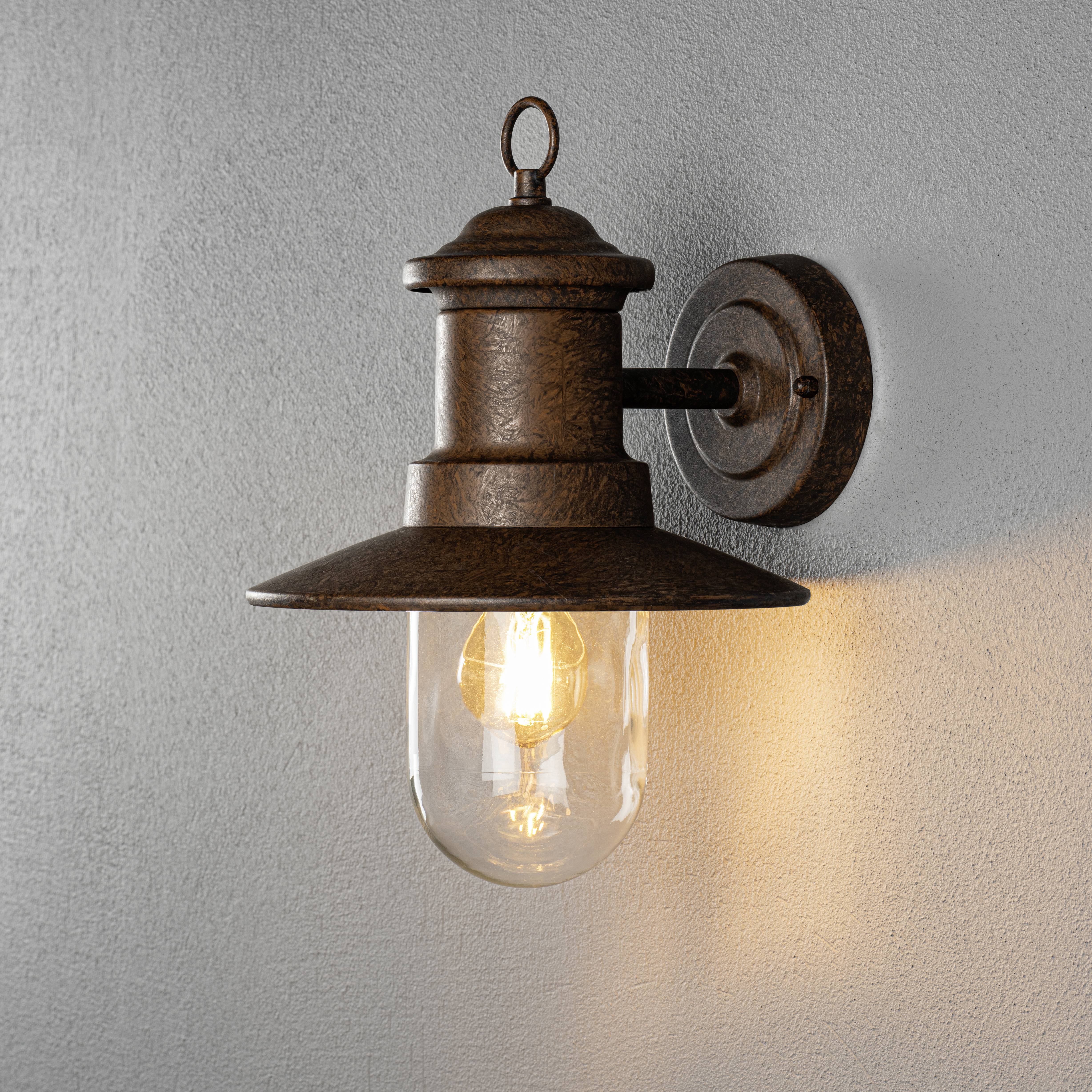 An der Wand montierte Vintage-Wandleuchte mit sichtbarer Glühbirne. Rustikales Design und warmes Licht erzeugen eine gemütliche Atmosphäre.