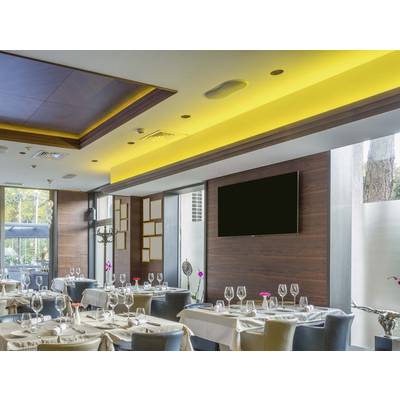 Ein elegantes Restaurant mit gedeckten Tischen, weißen Tischdecken und Weingläsern. Die Wände sind holzverkleidet, und es gibt warmes Deckenlicht.