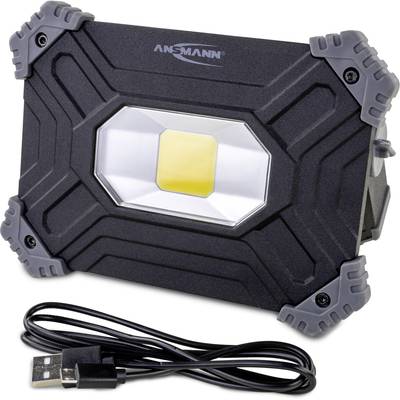 Schwarzer LED-Strahler mit grauen Ecken, Marke Ansmann, neben einem USB-Kabel.