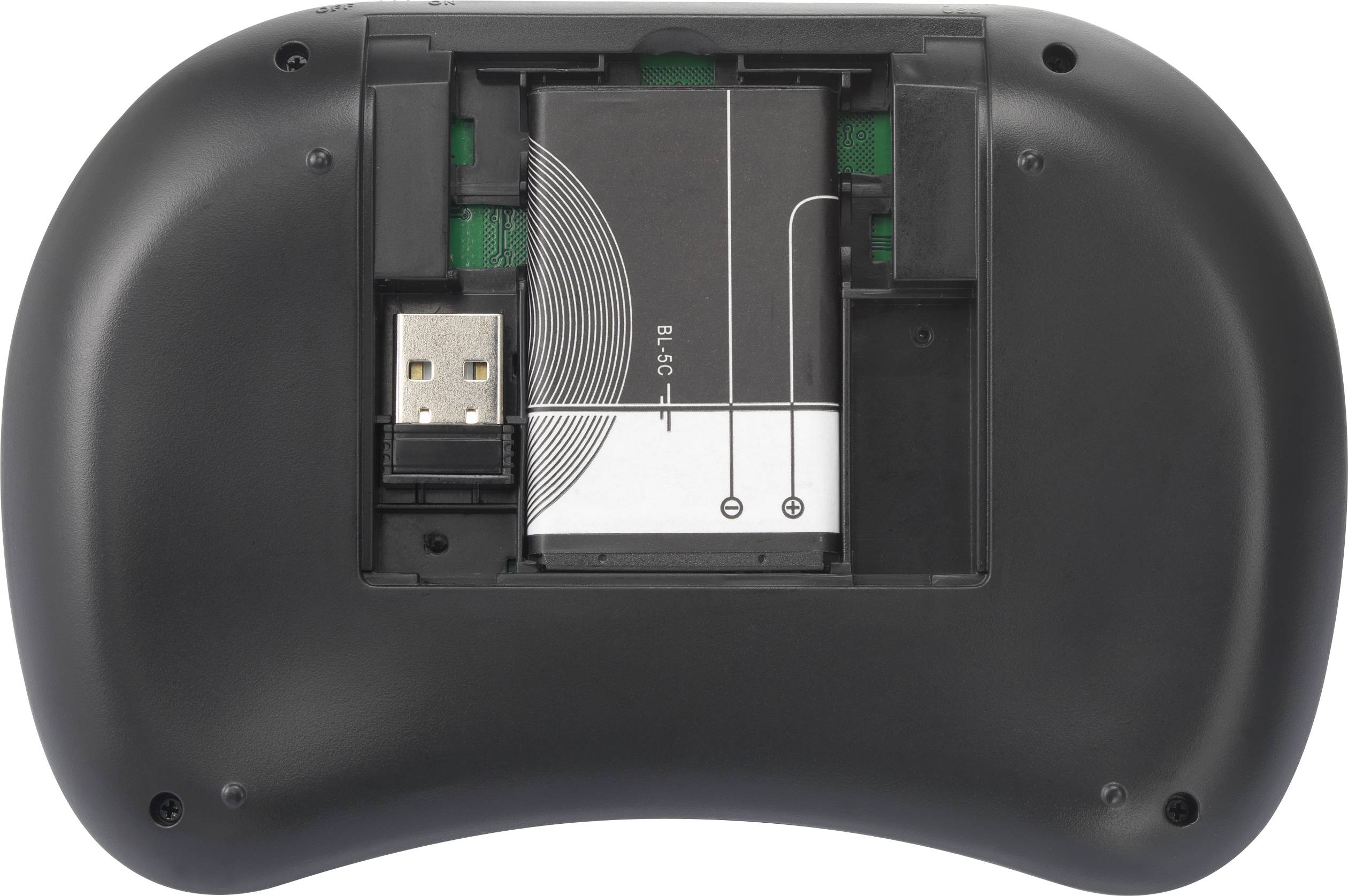 Die Rückseite eines schwarzen Game-Controllers mit geöffnetem Batteriefach, das einen USB-Empfänger und Batteriefach-Anschlüsse zeigt.