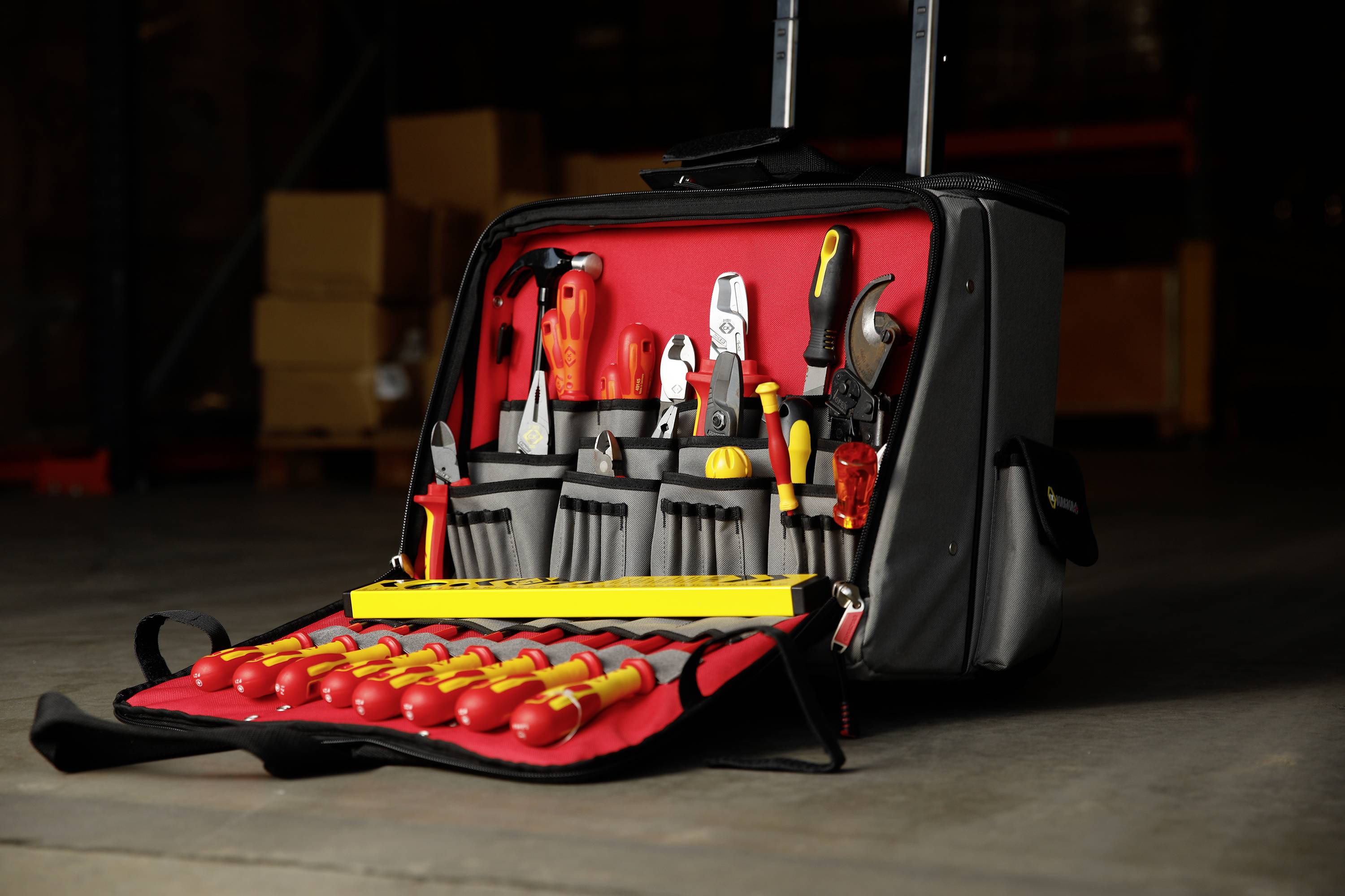 Werkzeugkoffer im Lager mit geöffnetem Deckel. Verschiedene Werkzeuge wie Schraubenzieher und Zangen sind übersichtlich angeordnet.