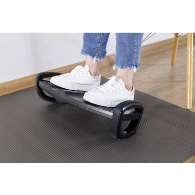 Eine Person balanciert auf einem Balance-Board mit weißen Turnschuhen. Das Board liegt auf einer dunklen Matte auf dem Boden.