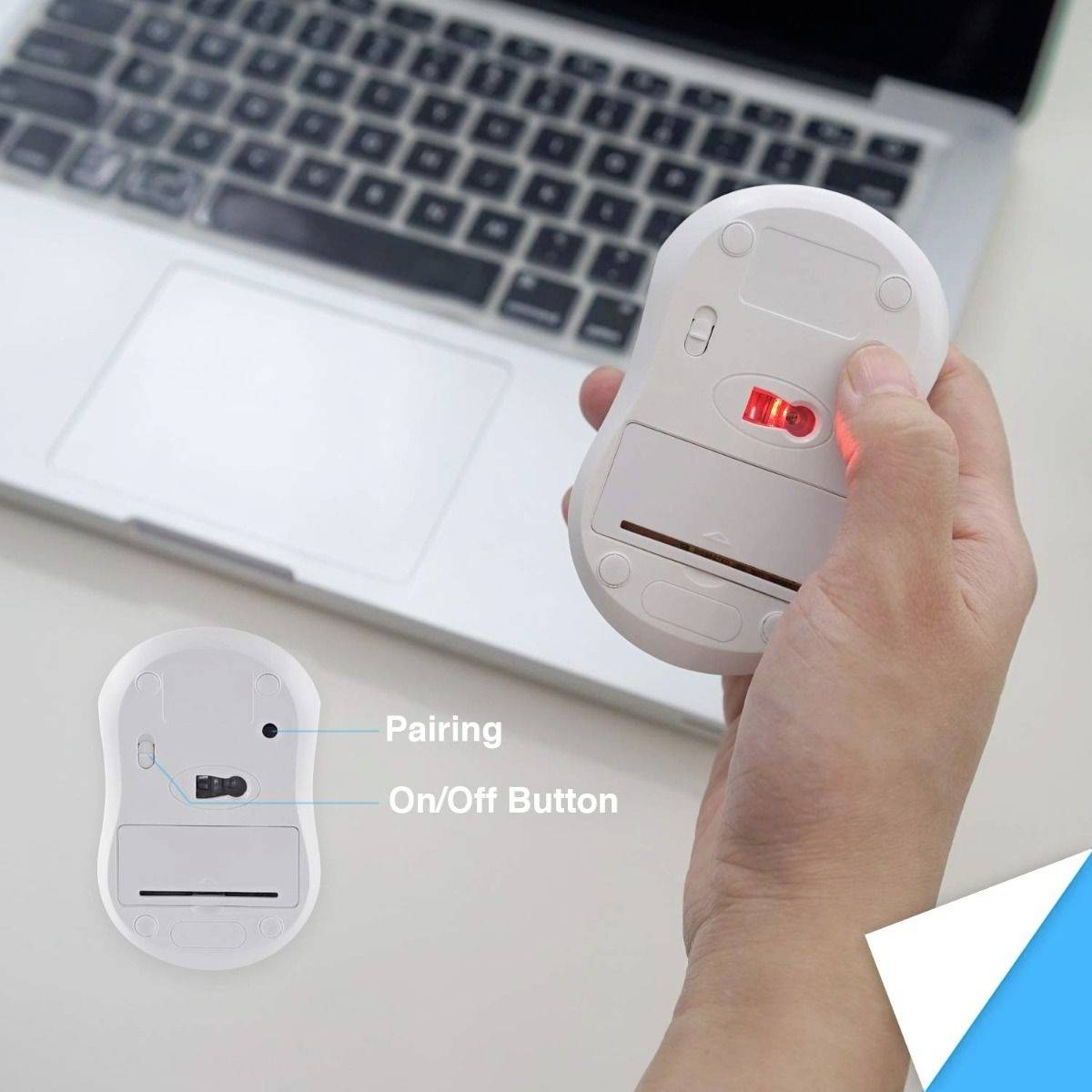 Eine Hand hält eine Maus, die Rückseite zeigt 'Pairing' und 'On/Off Button'. Ein Laptop ist im Hintergrund zu sehen.