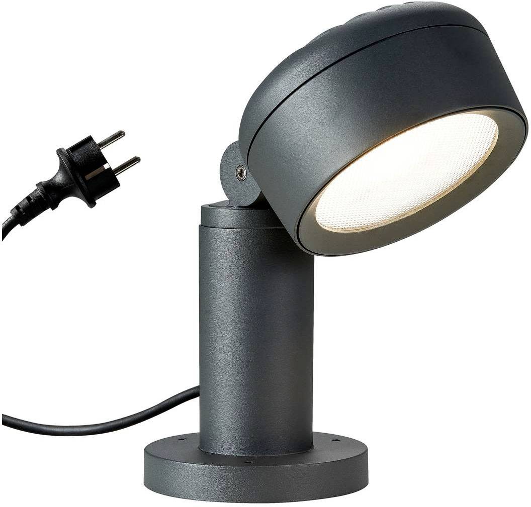 Eine schwarze, moderne Stehlampe mit runder Leuchte, steht aufrecht. Der Stromstecker ist sichtbar.