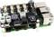 Ein schwarzes Computer-Board mit mehreren Anschlüssen und elektronischen Bauteilen, darunter USB-Ports und Kondensatoren, auf Kunststoffständern.