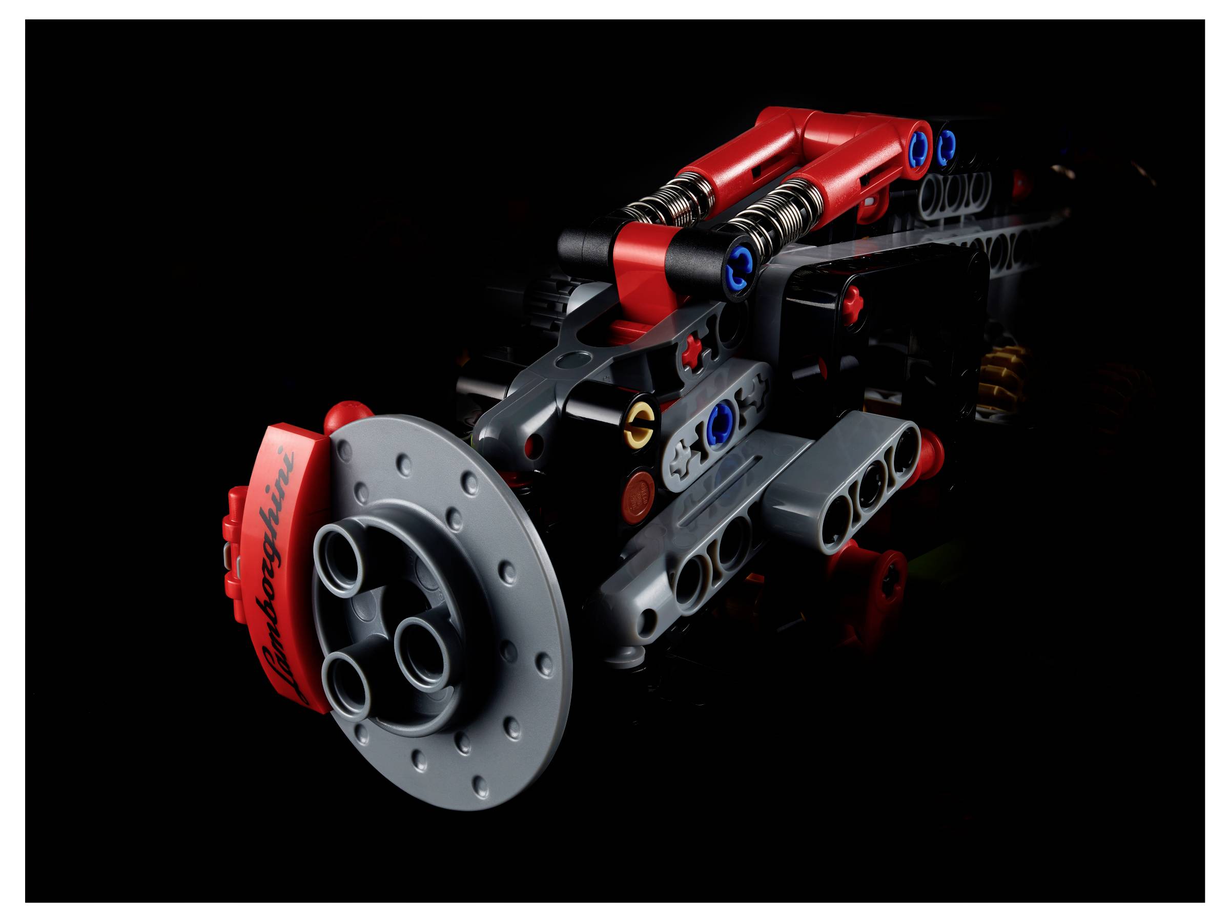 Eine Lego-Bremsscheibe eines Lamborghini-Modellautos, detailreich dargestellt, mit roten und grauen Komponenten auf schwarzem Hintergrund.