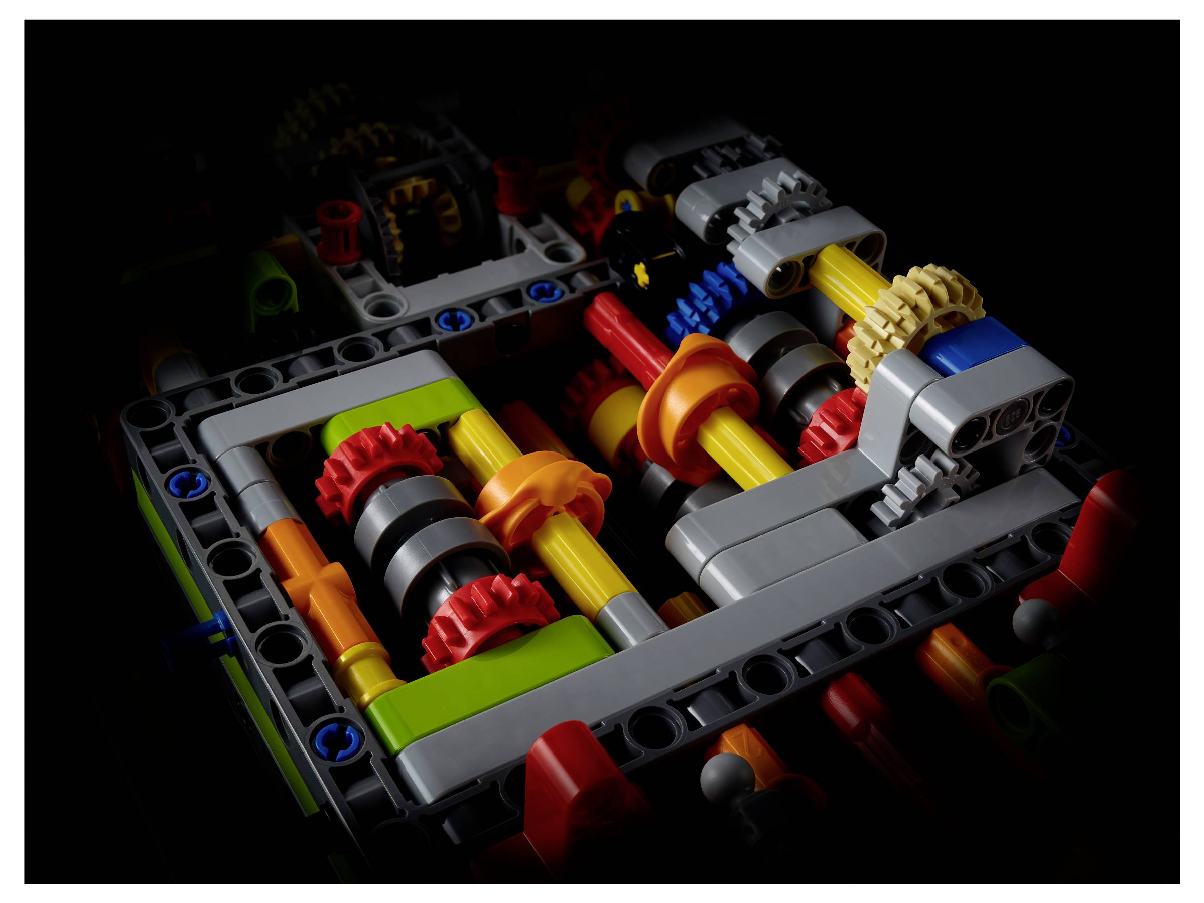 Lego-Modell eines Mechanismus mit Zahnrädern in verschiedenen Farben, die ineinandergreifen. Fokus auf mechanische Details und Strukturen.