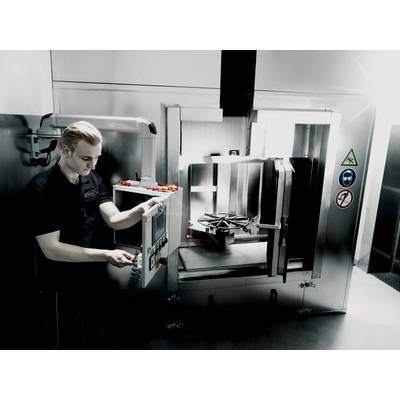 Eine Person bedient eine industrielle Maschine mit einem Schalttableau. Warn- und Sicherheitssymbole sind an der Maschine angebracht.