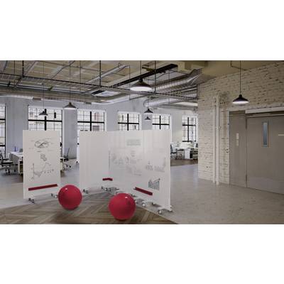 Offener Büoraum mit modernen Trennwänden und roten Sitzbällen. Weiße Tafeln zeigen Skizzen von Grafiken und Gebäuden. Industrieller Stil.