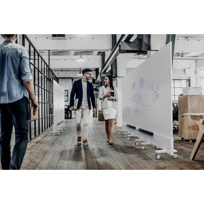 Ein Mann und eine Frau gehen und unterhalten sich in einem modernen Büro mit Whiteboards im Hintergrund.