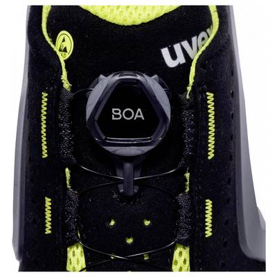 Schwarzer Schuh mit grünem Innenfutter, gelbem Logo und Drehverschluss 'BOA' in der Mitte für individuelle Anpassung.