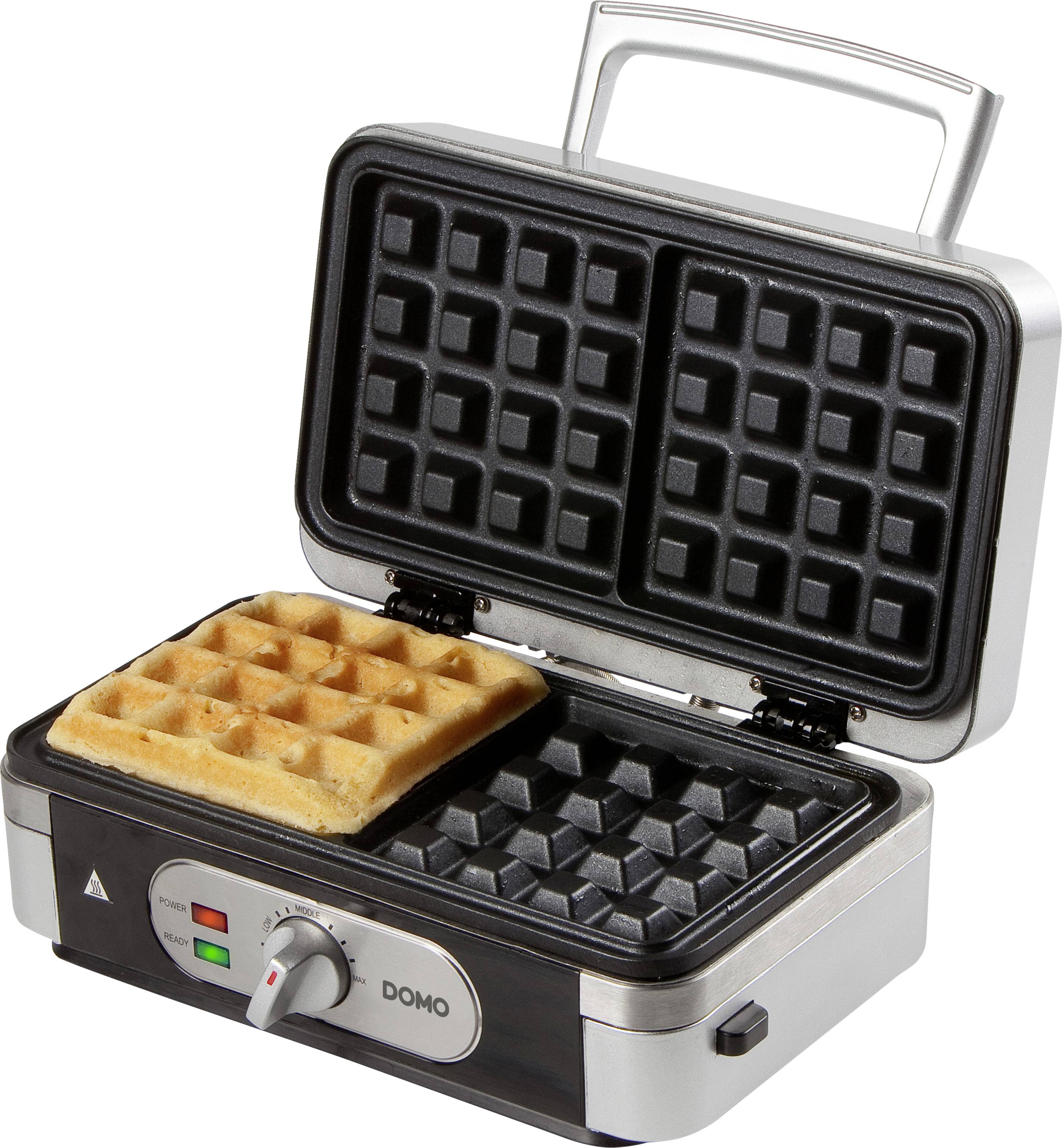 Waffeleisen mit Metallgehäuse, zwei rechteckige Formen. Eine Waffel fertig gebacken, die andere Form leer. Bedienknöpfe vorne sichtbar.