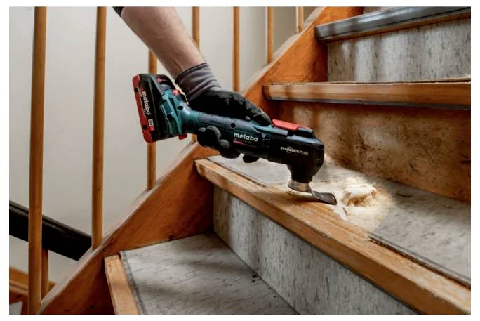 Technische Zeichnung eines elektrischen Elektrowerkzeugs mit Seiten-, Vorder- und Draufsicht mit Abmessungen und beschrifteten Details. Werkzeug der Marke „Metabo".