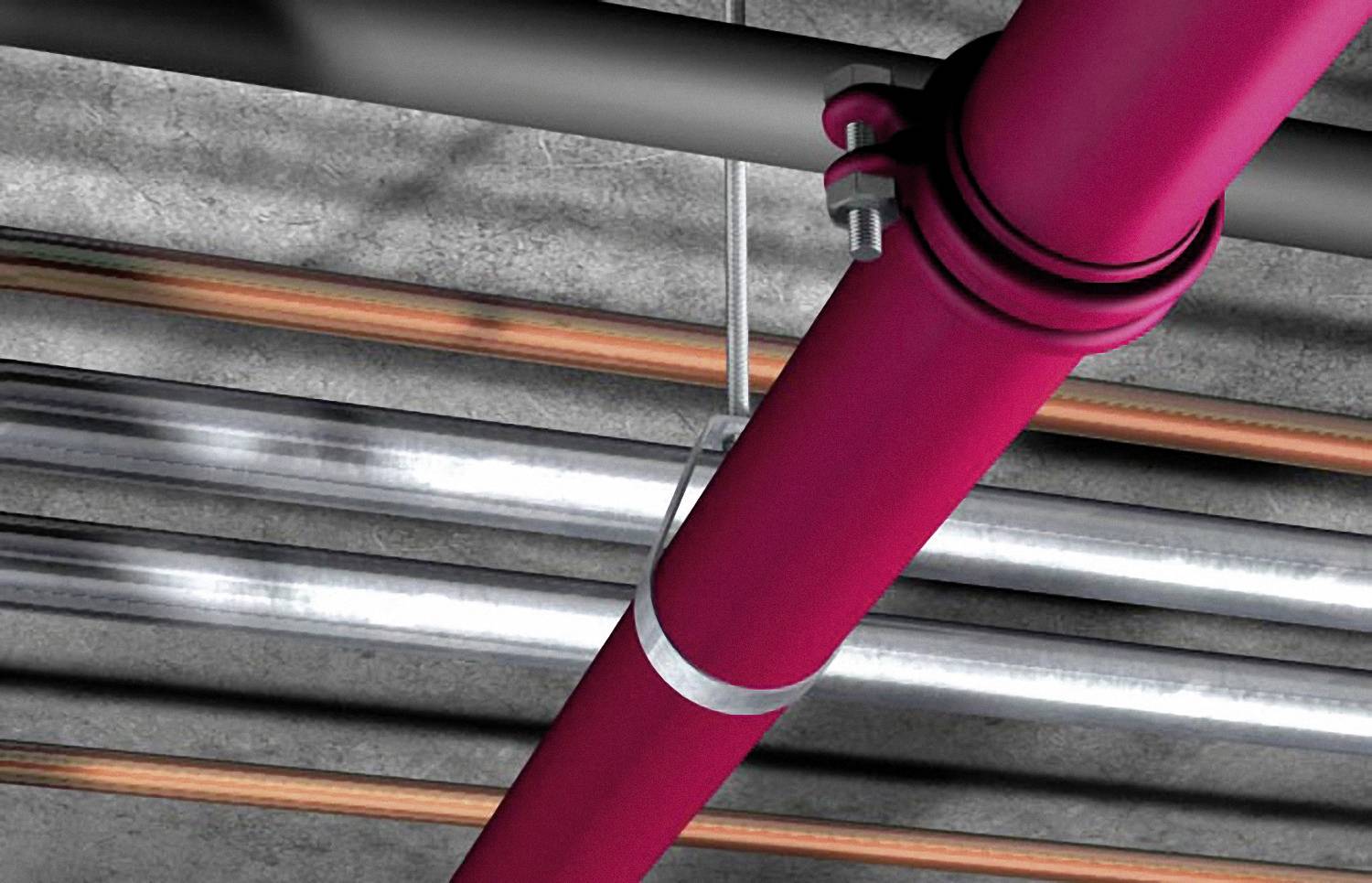 Rote und silberne Rohre verlaufen parallel an einer Betondecke. Ein rotes Rohr ist im Vordergrund befestigt.