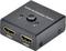 Ein schwarzer HDMI-Umschalter mit zwei HDMI-Anschlüssen und einem zentralen Knopf zur Auswahl von Anschluss 1 oder 2.