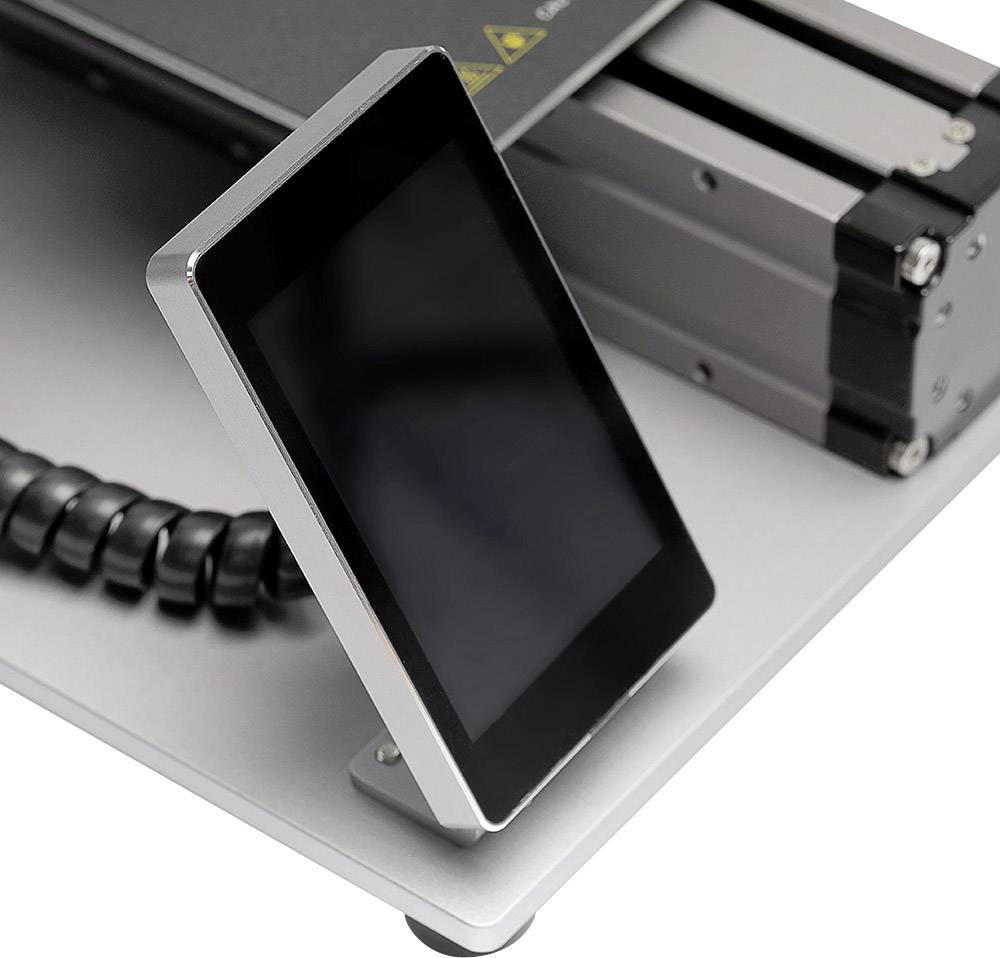 Ein schräg aufgestelltes Display mit schwarzem Bildschirm, verbunden mit einem Kabel, neben einer metallischen Maschinenkomponente.