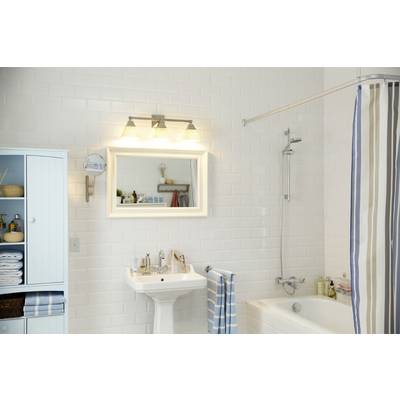 Helles Badezimmer mit weiß gefliesten Wänden, Badewanne, Duschvorhang und Waschbecken. Schrank mit Handtüchern links.